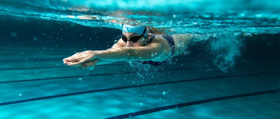 Female swimmer in pool with swim cap and goggles