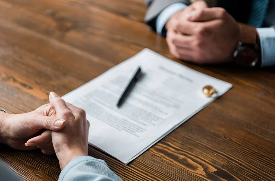 a man and woman sitting down with divorce paperwork on a table