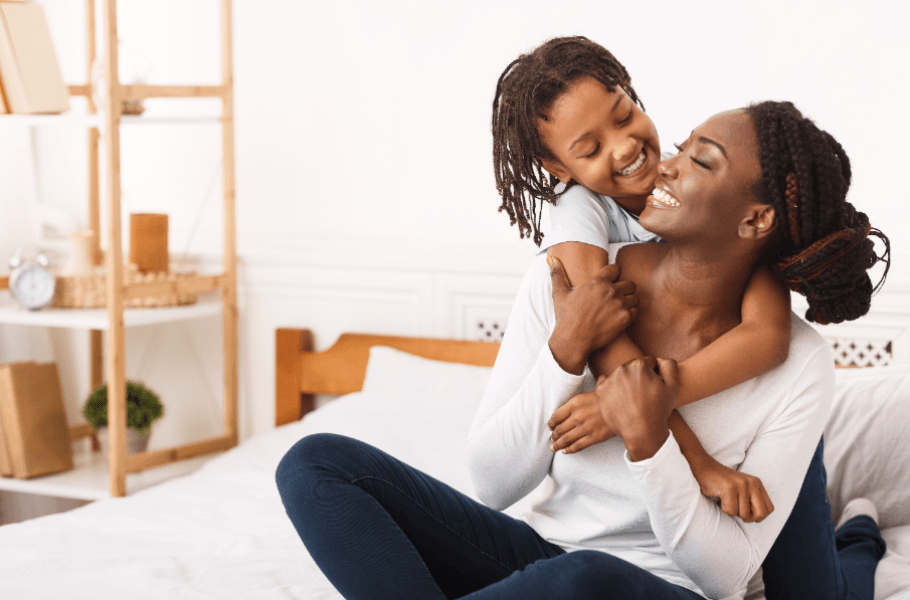 Mother and Child Smiling as Child Hugs Mother 